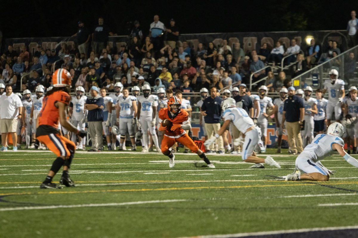 Senior Quarterback Colin Livatino looks to pass to Justin Johnson